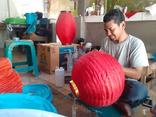 Perajin lampion saat mengerjakan pesanan untuk perayaan Tahun Baru Imlek (Arifina Cahyanti Firdausi/MalangTIMES)