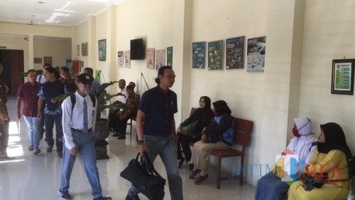 Terdakwa pembunuh begal (seragam abu-abu pakai topi dan masker) saat menuju ruang persidangan (Foto : Ashaq Lupito / MalangTIMES)