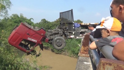 Kondisi truk trailer nyaris tercebur ke Kali Gunting pasca mengalami laka tunggal di jalan raya Bay Pass Mojoagung, Jombang. (Istimewa)