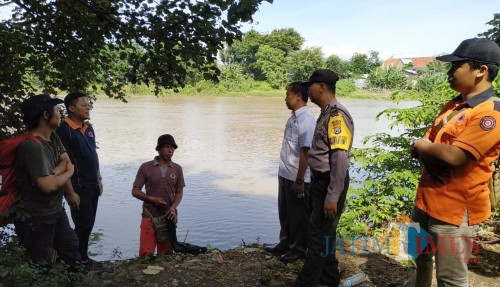 Petugas gabungan menyisir pinggiran sungai mencari buaya muara yang menghebohkan masyarakat. (eko Arif s /JatimTimes)
