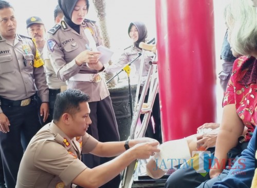 Kapolres Blitar AKBP Budi Hermanto mengukur kaki palsu penyandang disabilitas yang mendapat bantuan kaki palsu.(Foto : Team BlitarTIMES)