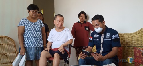 Denny Irawan (baju biru) saat memeriksa dokumen kependudukan Lai Chin Cheung (baju putih) (Joko Pramono for Jatim Times)