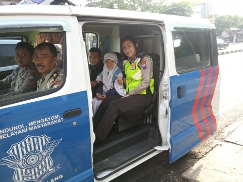 Terlihat nampak anggota Dikyasa Polresta Malang Kota mengantarkan dua anak yang nyaris saja tak bisa berangkat sekolah karena motor sang ayah yang mengalami ban kempes (Ist)