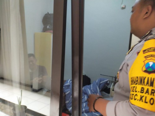 Terlihat korban yang mencoba bunuh diri tengah dibujuk Bhabinkamtibmas Kelurahan Bareng, yakni Bripka Lucky agar mengurungkan aksinya. (Foto: Istimewa)