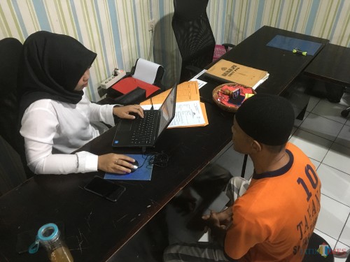 Atmari (baju tahanan warna oranye), tersangka persetubuhan anak di bawah umur saat dimintai keterangan di hadapan penyidik Unit PPA Satreskrim Polres Malang. (Foto : Ashaq Lupito / MalangTIMES)