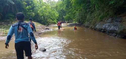 Petugas saat melakukan penyisiran guna mencari keberadaan balita yang dikabarkan hanyut terbawa arus sungai.