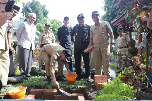 Proses pemasangan sumur injeksi yang turut dilakukan oleh Wali Kota Malang Sutiaji (pegang ember oeange) di Kecamatan Blimbing, Selasa (11/2) (Foto: Humas Pemkot Malang)