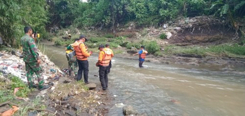 Petugas saat melakukan penyisiran guna mencari keberadaan balita yang diduga hanyut terbawa arus drainase saat banjir.