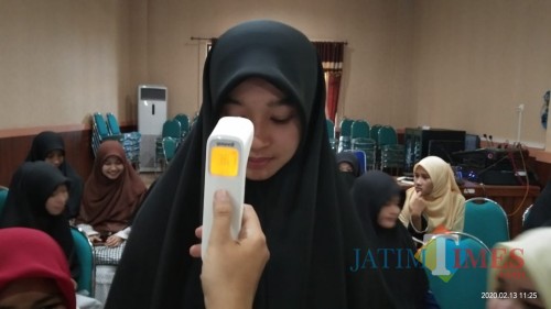 salah satu mahasiswa Thailand diperiksa suhu tubuhnya menggunakan thermal scanner (pengukur suhu) (Joko Pramono for Jatim Times)