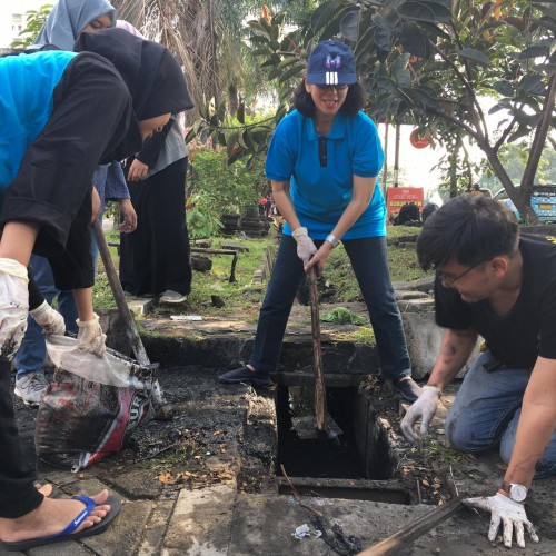 Kepala DLH Kota Malang Rinawati (kaus biru, bertopi) saat ikut turun ke lapangan untuk membersihkan selokan di Jalan Soekarno-Hatta. (DLH for malang times)