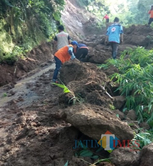 Petugas saat mengevakuasi material longsor yang menutup akses jalan antar dua desa di Kecamatan Pujon. (Foto: PMI Kabupaten Malang for MalangTIMES)