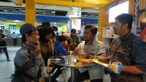 Petugas layanan Mandiri Syariah saat memeragakan pembukaan rekening online pada pengunjung (Arifina Cahyanti Firdausi/MalangTIMES)