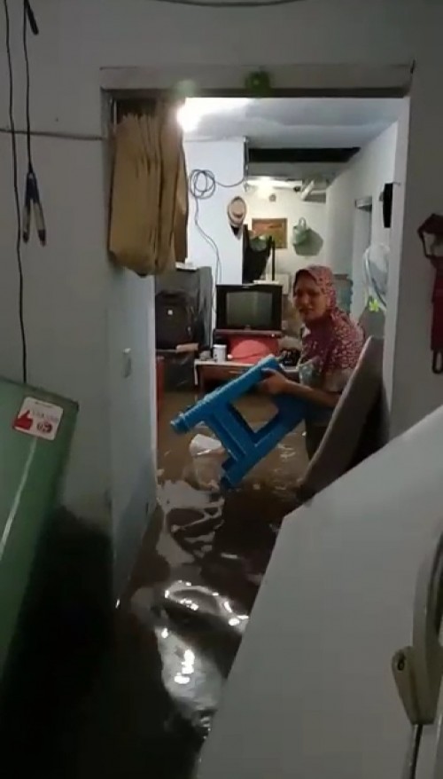 Nampak seorang ibu-ibu yang tengah menyelamatkan perabotannya yang terkena banjir (ist)
