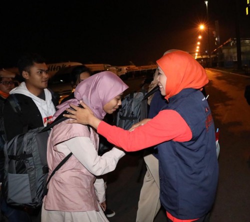 Gubernur Jawa Timur Khofifah Indar Parawansa (jilbab orange) saat menyambut kedatangan 65 warga Jatim dari Natuna, Kepri, Sabtu malam (15/2) (Foto: istimewa)