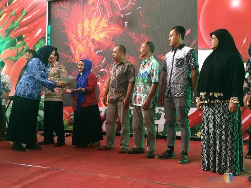 Wali Kota Batu Dewanti Rumpoko saat menyerahkan sertifikat kepada warga yang berhal menerima di Pasar Sayur Kota Batu, Senin (17/2/2020). (Foto: Irsya Richa/MalangTIMES)