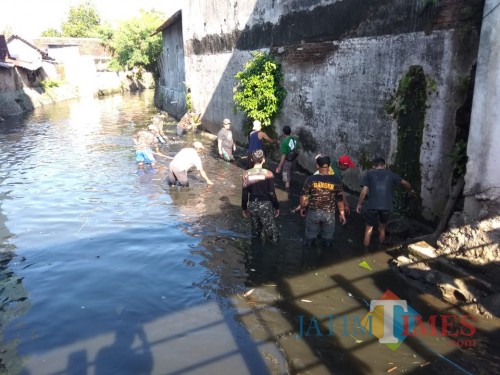 Anggota Banser Tulungagung membersihkan sampah di Kali Jenes (Joko Pramono for JatimTIMES)