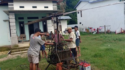 Kaharuddin (40) sedang melakukan penghidupan helikopter rakitan dibantu teman-temannya. (Foto: Istimewa)