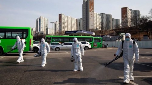 Petugas Kesehatan menyemprotkan disinfektan dengan memakai pakaian pelindung di wilayah Korea Selatan. (Foto: Istimewa)