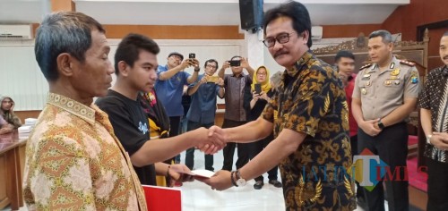 Sekda Kota Blitar Rudi Wijanarko secara simbolik menyerahkan bantuan kepada warga terdampak kerusuhan suporter sepak bola.(Foto : Team BlitarTIMES)