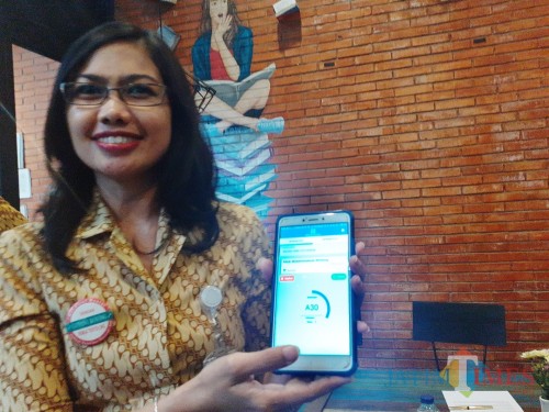 Kepala BPJS Cabang Malang Dina Diana Permata saat menunjukkan cara penggunaan fiture antrean online melalui aplikasi JKN. (Arifina Cahyanti Firdausi/MalangTIMES)