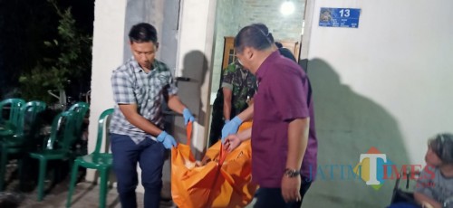 Petugas mengevakuasi jasad Sukemi