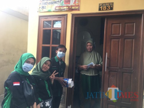 Kader HMI Brawijaya saat 'door to door' membagikan masker dan vitamin ke warga perkampungan Karangbesuki secara gratis.
