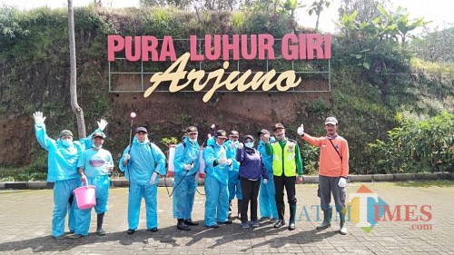 Para petugas menyemprot di Pura Giri Arjuna, Desa Tulungrejo, Kecamatan Bumiaji, Sabtu (21/3/2020). (Foto: istimewa)