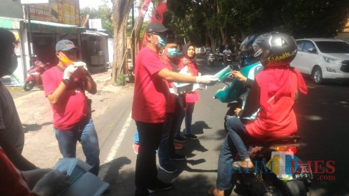 Suasana pembagian masker dan minuman kesehatan di depan Kantor PDI Perjuangan Banyuwangi. (Nurhadi Banyuwangi TIMES)