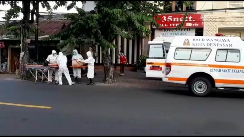 WNA yang tergelatak di pinggir jalan dan saat dilakukan evakuasi oleh petugas medis.