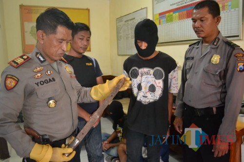 Kapolsek Mojowarno AKP Yogas saat menunjukkan barang bukti parang milik pelaku pembacokan. (istimewa)