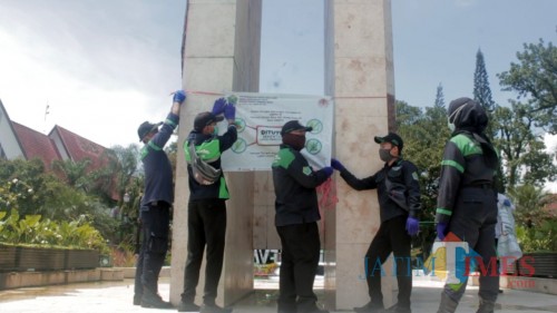 Pramu-taman saat melakukan pemasangan banner larangan masuk taman sementara di taman Jalan Ijen. (Igoy)