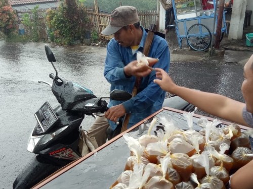 Salah satu anggota Karang Taruna saat membagikan jamu kepada masyarakat di Desa Sumbergondo, Kecamatan Bumiaji, Jumat (27/3/2020). (Foto: istimewa)