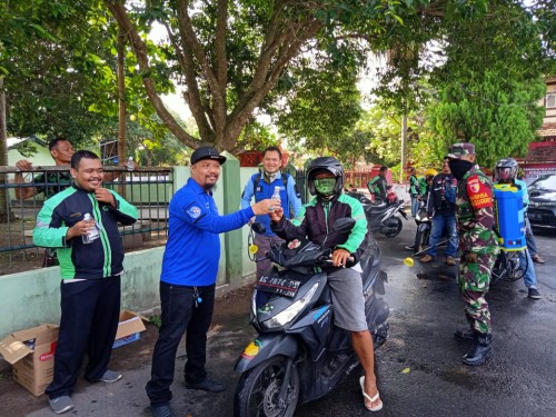 Ketua DPC Partai Demokrat Kota Blitar, Ito Tubagus Aditya memimpin langsung penyemprotan disinfektan dan bagi hand sanitizer kepada driver ojek online (Foto: Aunur Rofiq/BlitarTIMES)