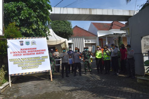 Kapolres Batu AKBP Harviadhi Agung Prathama bersama petugas saat melakukan penjagaan saat physical distanding di perumahan. (Foto: istimewa)