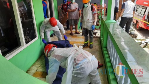 Petugas saat mengevakuasi jenasah di Kecamatan Sumberpucung yang ditemukan meninggal dunia didepan rumahnya (Foto : Polsek Sumberpucung for MalangTIMES)