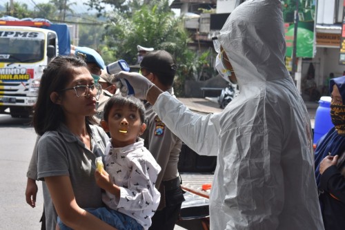 Petugas saat memeriksa suhu tubuh di simpang tiga Pendem, Kecamatan Junrejo dan jalan Klemuk, Kelurahan Songgokerto, Kecamatan Batu, Jumat (3/4/2020). (Foto: Istimewa)