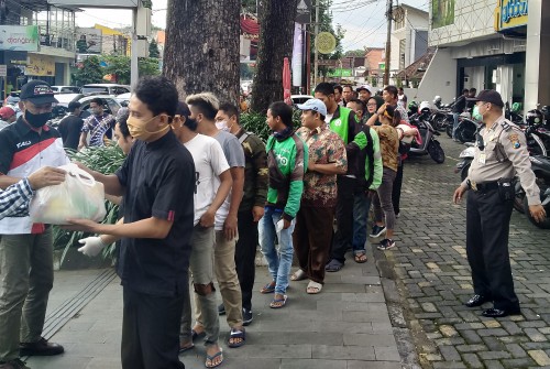 Nampak para driver ojek online yang berjumlahnya ratusan sempat memadati depan sebuah ruko di Jalan Kawi dengan penjagaan polisi (Anggara Sudiongko/MalangTIMES)