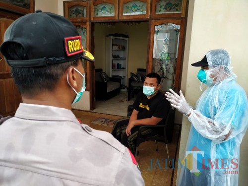 AH saat didatangi petugas dirumahnya untuk dijemput dan dipindah ke asrama rusunawa tempat Karantina / Foto : Anang Basso / Tulungagung TIMES
