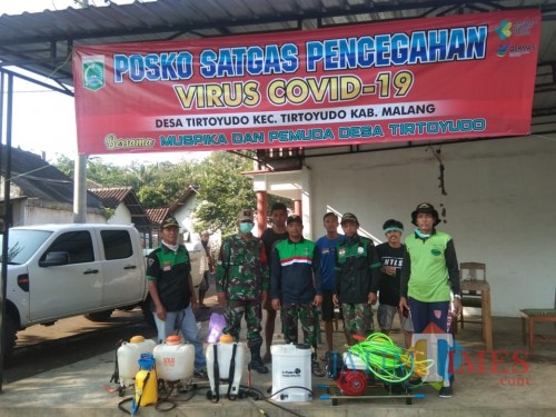 Petugas saat mempersiapkan diri sebelum menyemprotkan cairan disinfektan berbahan serai untuk menangkal penyebaran virus covid-19