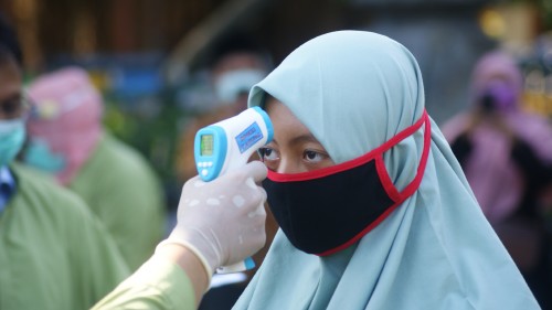 Salah satu santri diperiksa suhunya dengan thermo gun oleh tim kesehatan (Joko Pramono for JatimTIMES)
