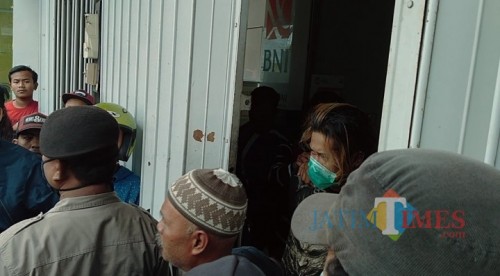 Warga yang nampak berkumpul mengepung pelaku pencurian yang bersembunyi dalam ruko (Anggara Sudiongko/MalangTIMES)
