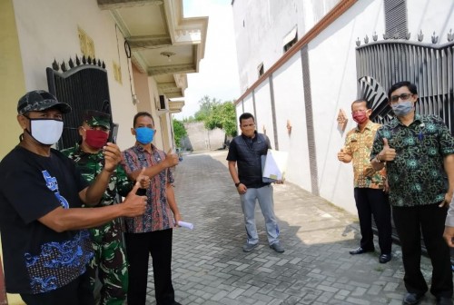 AH (bawa kantong plastik) saat meninggalkan lokasi karantina (ist)
