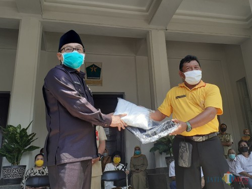 Direktur Utama Hawai Grup Bambang Judo Utomo (kanan) saat menyerahkan bantuan APD secara simbolis kepada Wali Kota Malang Sutiaji, di Balaikota Malang, Selasa (14/4). (Arifina Cahyanti Firdausi/MalangTIMES)