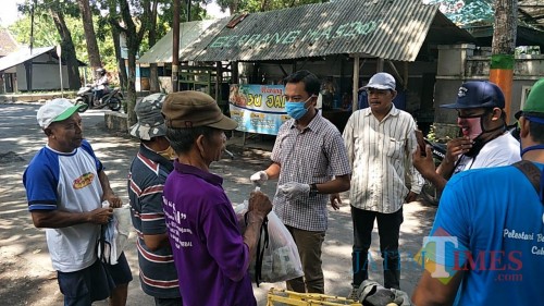 Ketua Paguyuban Kicau Mania ketika menyerahkan sembako kepada warga (Foto : Moch. R. Abdul Fatah / Jatim TIMES)