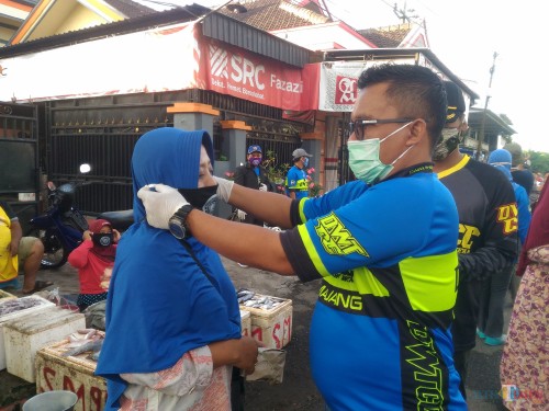 H. Idris Marzuki S.Pd ketika memberikan bantuan masker di Pasar Dawuhan Wetan (Foto : Moch. R. Abdul Fatah / Jatim TIMES)