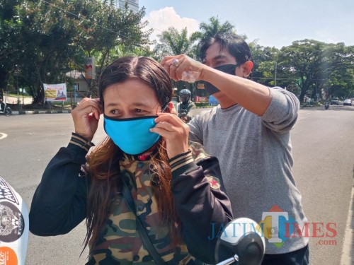 Camat Lowokwaru, Imam Badar saat memakaikan masker pada pengendara yang tak bermasker (Istimewa).