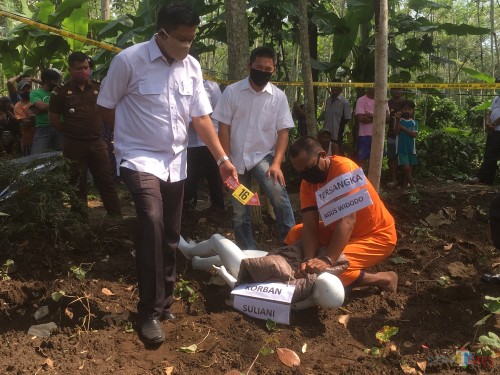 Tersangka Agus Widodo (jongkok) saat memperagakan adegan saat dirinya membunuh istrinya (Foto: Ashaq Lupito/ MalangTIMES)