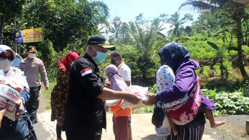 Bupati Malang H.M. Sanusi menyalurkan bantuan beras seberat lima kilogram kepada warga di Kecamatan Ampelgading, Kamis (23/4/2020). (Foto: Dok. Malang Times)