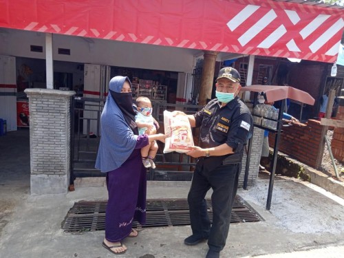 Bupati Malang, HM Sanusi saat membagikan sembako kepada salah satu warga di kawasan Malang Timur