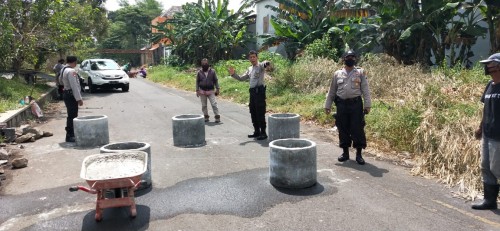 Petugas Polsekta Kedungkandang memasang beton-beton bis dibelakang Gor Ken Arok untuk antisipasi balap liar (Ist)